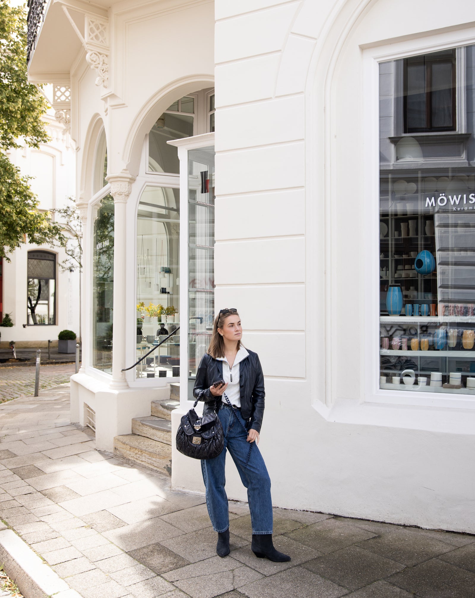 Lederjacke Linneah in Navy in ganzer Figur, zu weißem Troyer, weiter Jeans und dunklen Stiefeletten