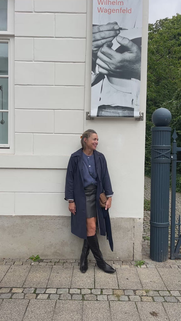 Strickjacke Charlotteh in Blau in Bewegung, zum Lederrock, Mantel über der Schulter